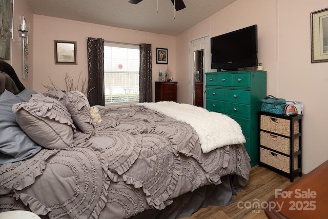 bedroom featuring wood-type flooring, a textured ceiling, and ceiling fan