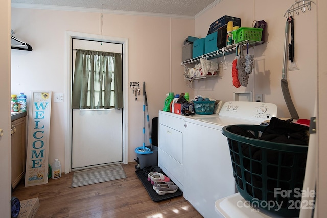 clothes washing area featuring hardwood / wood-style floors, crown molding, washer and dryer, and a textured ceiling