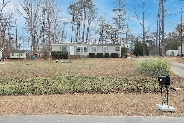 manufactured / mobile home featuring an outbuilding and a front yard