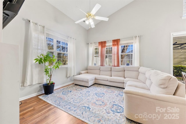 living room featuring hardwood / wood-style floors, high vaulted ceiling, and ceiling fan