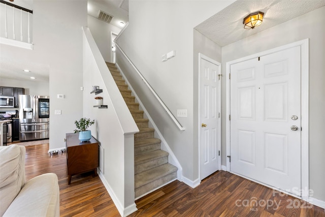 entryway featuring a textured ceiling and dark hardwood / wood-style floors