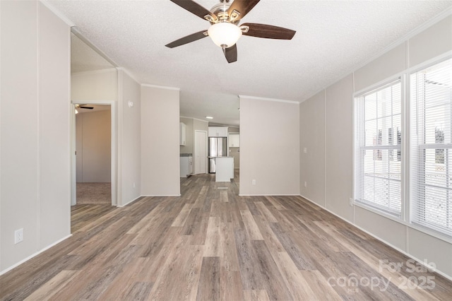 unfurnished living room with ornamental molding, ceiling fan, light hardwood / wood-style flooring, and a textured ceiling