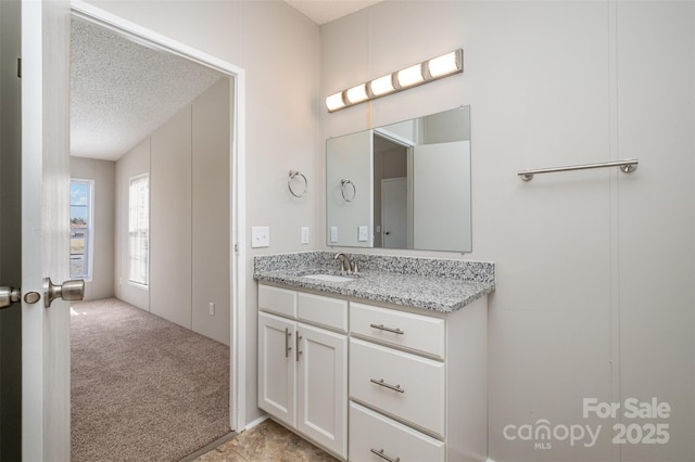 bathroom featuring a textured ceiling and vanity