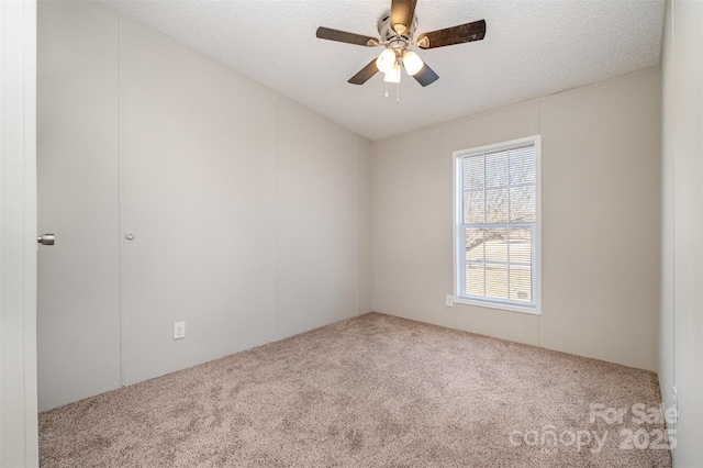 carpeted empty room featuring ceiling fan and a textured ceiling