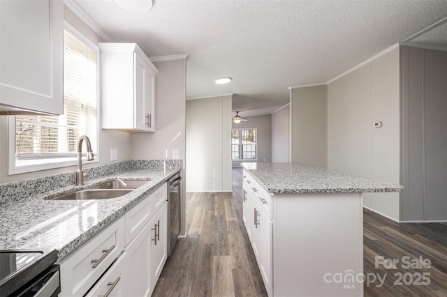 kitchen with a center island, light stone countertops, dishwasher, white cabinetry, and sink