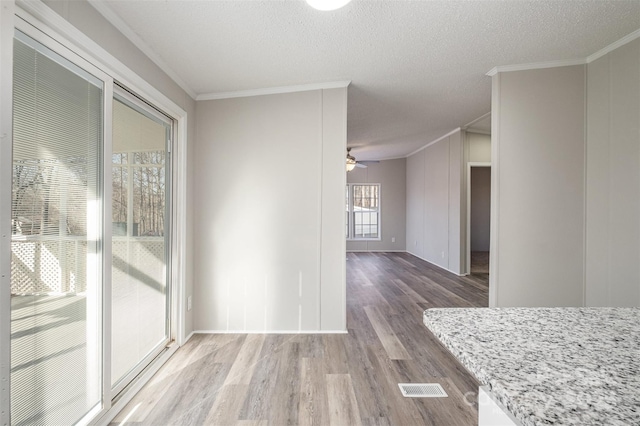 interior space featuring crown molding, hardwood / wood-style floors, and a textured ceiling