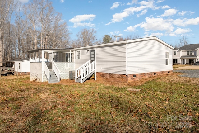 rear view of property with a yard and central AC