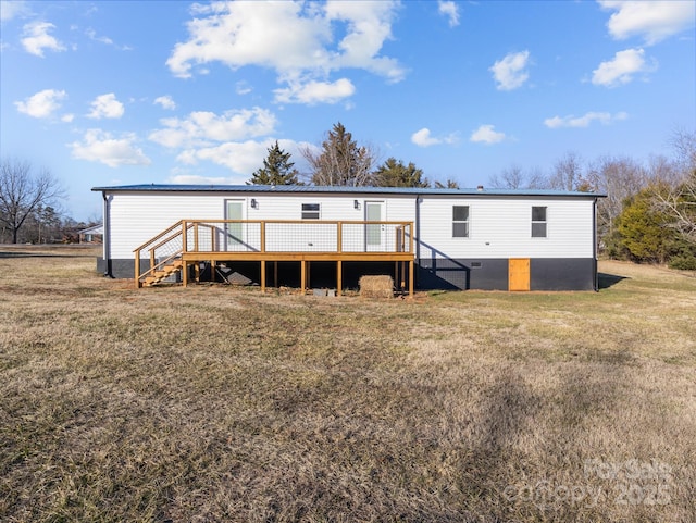 back of house featuring a deck and a lawn