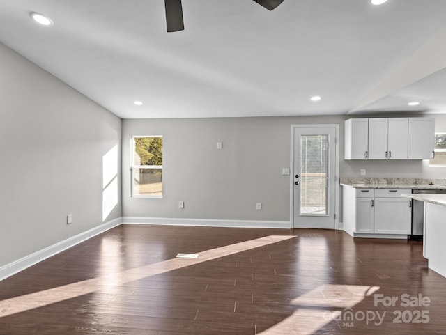 kitchen featuring ceiling fan, white cabinets, dark wood-type flooring, and light stone countertops