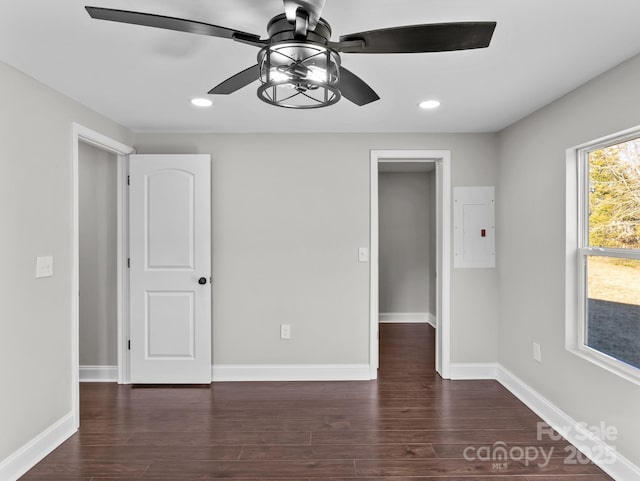 unfurnished room with ceiling fan, electric panel, and dark hardwood / wood-style floors