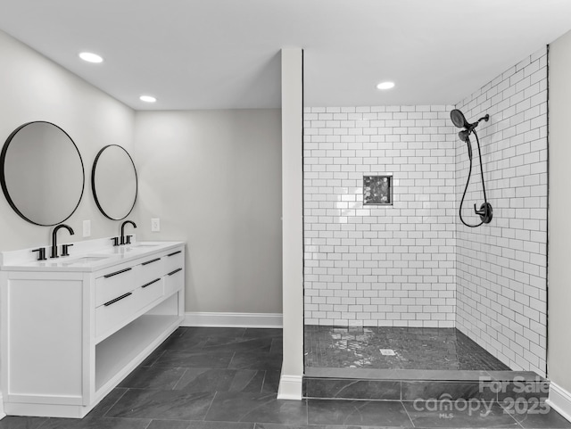 bathroom with vanity, a tile shower, and tile patterned flooring