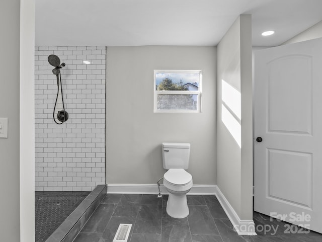 bathroom with toilet and a tile shower