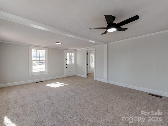 empty room with ceiling fan, ornamental molding, and light carpet