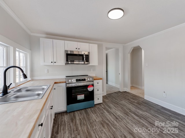 kitchen with sink, wooden counters, white cabinetry, and appliances with stainless steel finishes