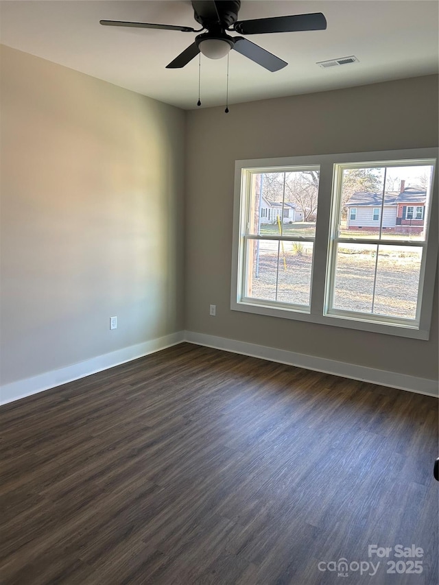 spare room with ceiling fan and dark hardwood / wood-style flooring