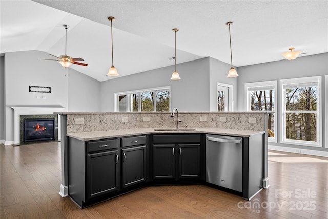 kitchen with dark hardwood / wood-style floors, dishwasher, sink, and a center island with sink