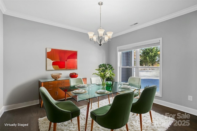 dining area featuring dark hardwood / wood-style flooring, crown molding, and a chandelier