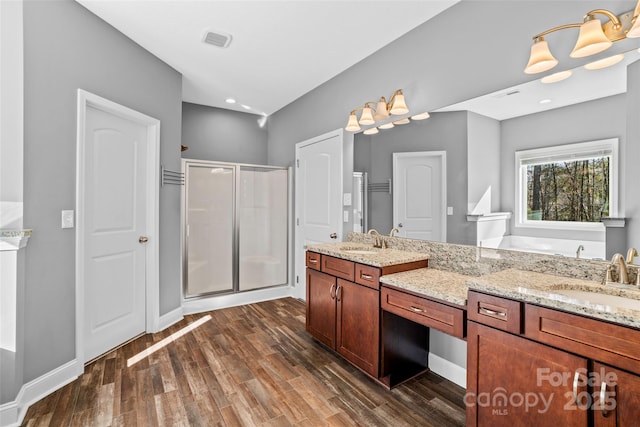 bathroom featuring wood-type flooring, separate shower and tub, and vanity