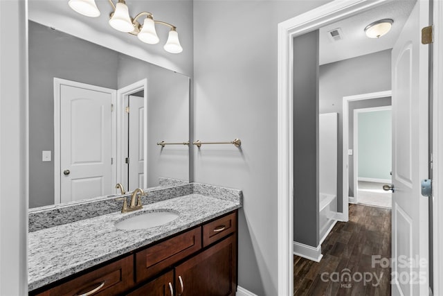 bathroom with vanity, a bath, a textured ceiling, and hardwood / wood-style floors