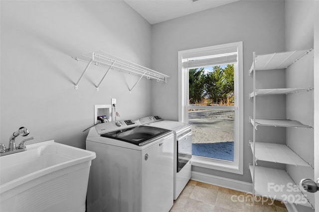 laundry area with independent washer and dryer and sink