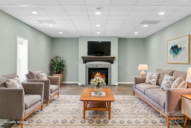 living room featuring a drop ceiling and hardwood / wood-style floors