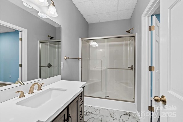 bathroom featuring an enclosed shower, vanity, and a paneled ceiling