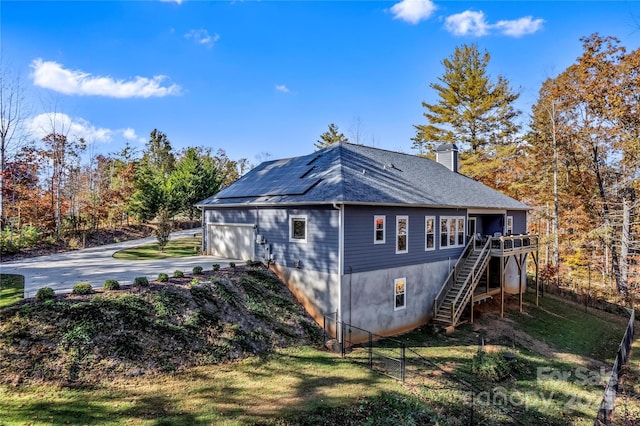 view of side of home featuring a garage and solar panels