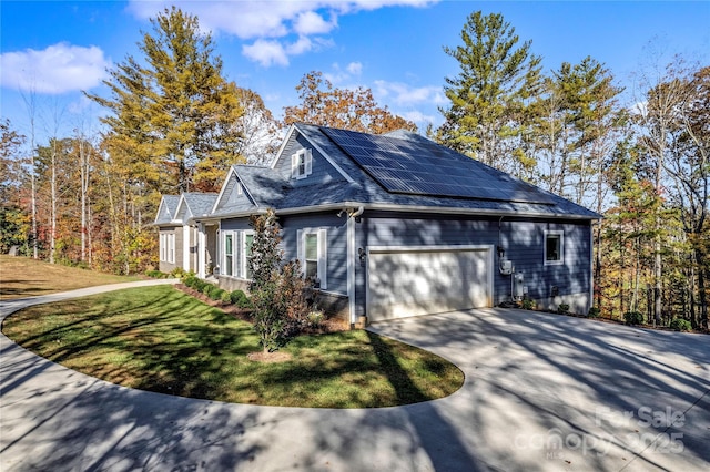 view of side of home with a garage, a lawn, and solar panels