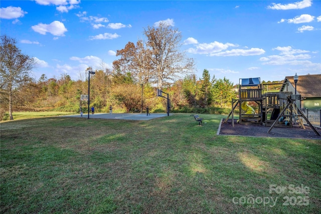 view of yard featuring a playground and basketball hoop