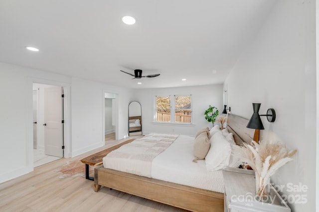 bedroom featuring hardwood / wood-style floors, a spacious closet, ceiling fan, and ensuite bathroom