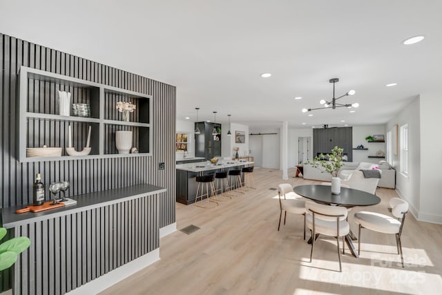 dining space with a notable chandelier and light wood-type flooring