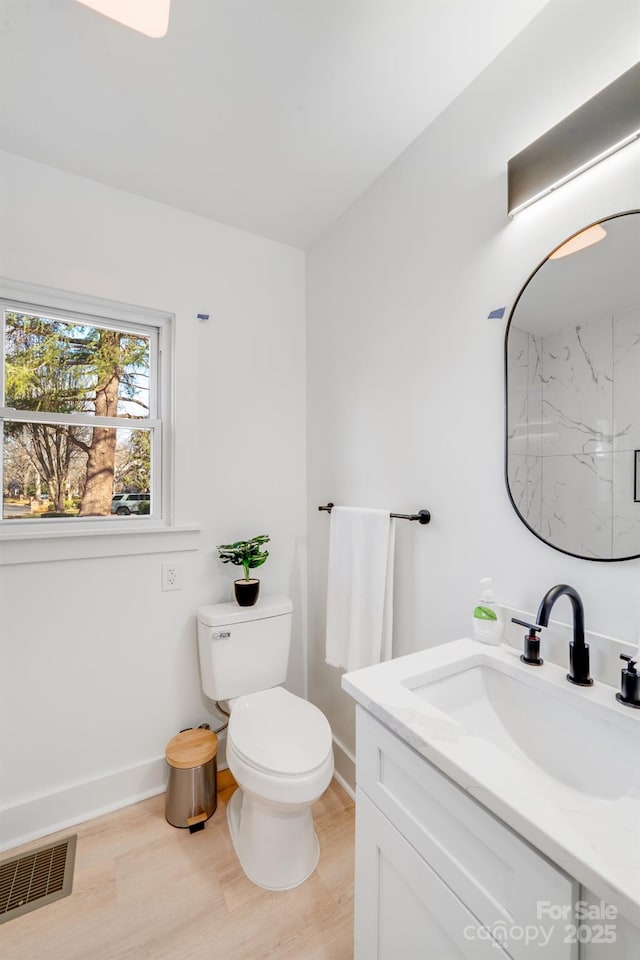 bathroom featuring vanity, hardwood / wood-style floors, a shower, and toilet