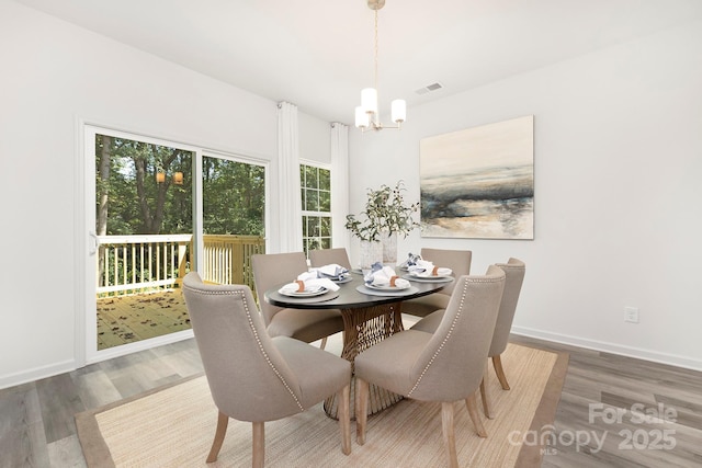 dining space featuring a chandelier and dark wood-type flooring