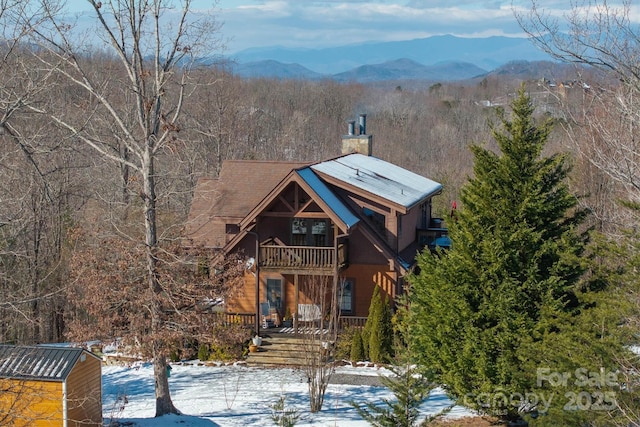 view of front facade featuring a mountain view, a storage shed, and a balcony