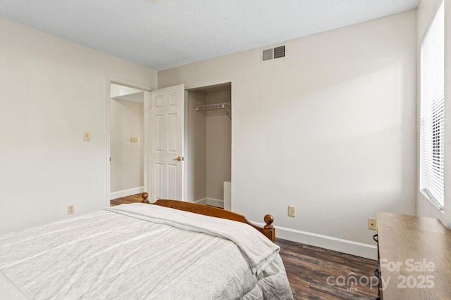 bedroom featuring dark hardwood / wood-style floors, a closet, and a textured ceiling