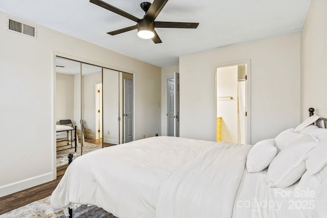 bedroom featuring dark wood-type flooring, a closet, and ceiling fan