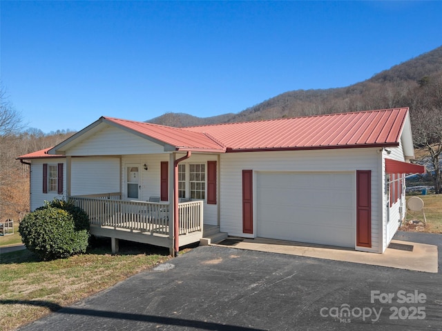 ranch-style house with a garage, a porch, and a mountain view