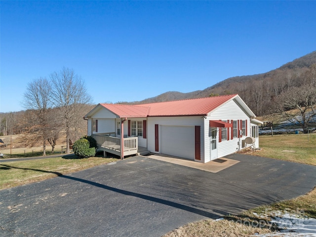 view of front facade featuring a front yard, a garage, and a mountain view