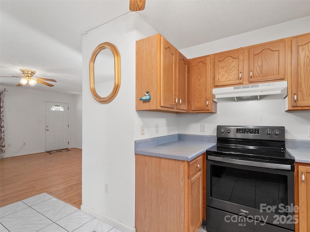 kitchen featuring ceiling fan, electric stove, and light wood-type flooring