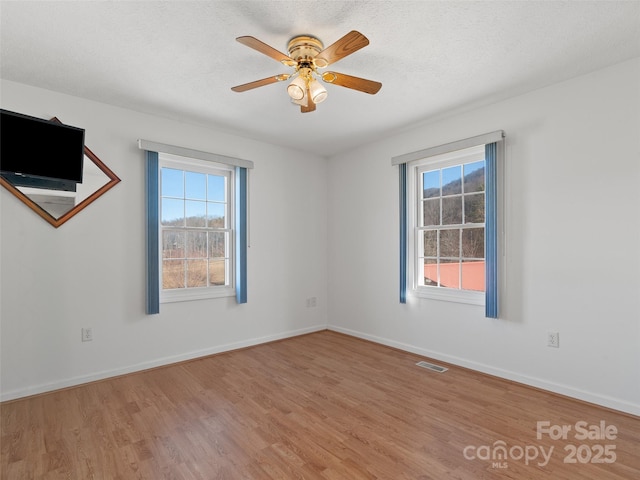 spare room featuring ceiling fan, wood-type flooring, and a textured ceiling