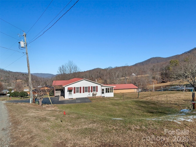 view of front of house featuring a mountain view and a front lawn