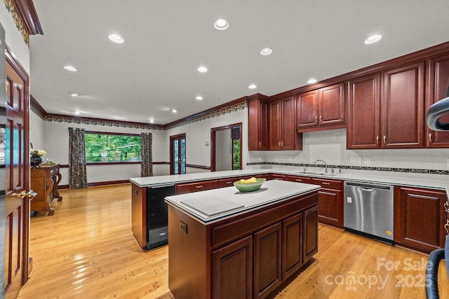 kitchen featuring kitchen peninsula, stainless steel dishwasher, light wood-type flooring, a kitchen island, and beverage cooler