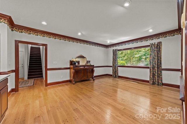 interior space with light wood-type flooring and crown molding