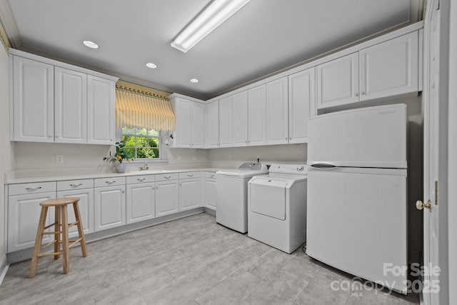 washroom featuring sink, cabinets, and independent washer and dryer