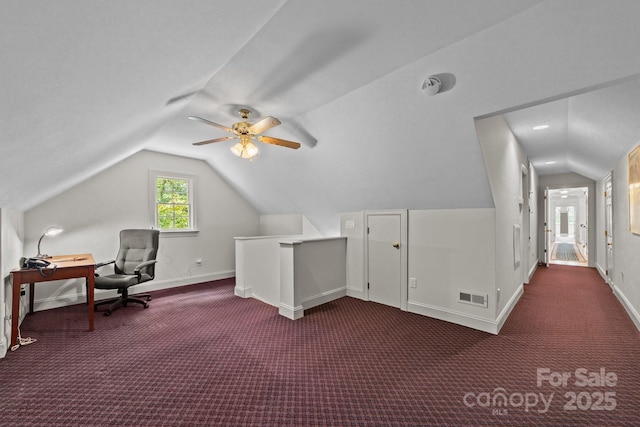 bonus room with dark colored carpet and vaulted ceiling