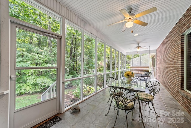 unfurnished sunroom featuring ceiling fan