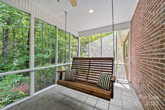 unfurnished sunroom with ceiling fan