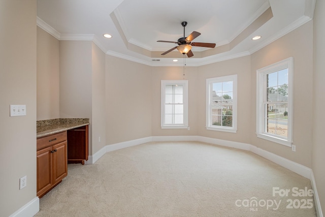 interior space featuring crown molding, a tray ceiling, and ceiling fan