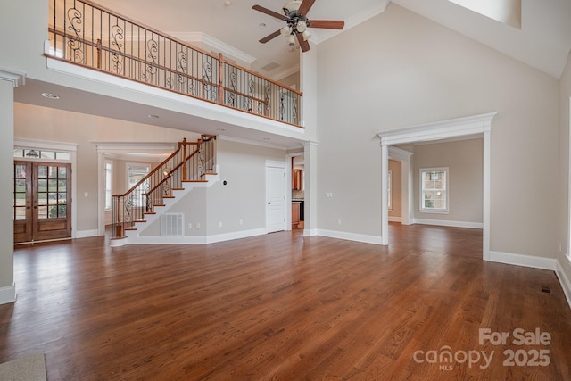 unfurnished living room featuring french doors, ceiling fan, dark hardwood / wood-style flooring, and a high ceiling