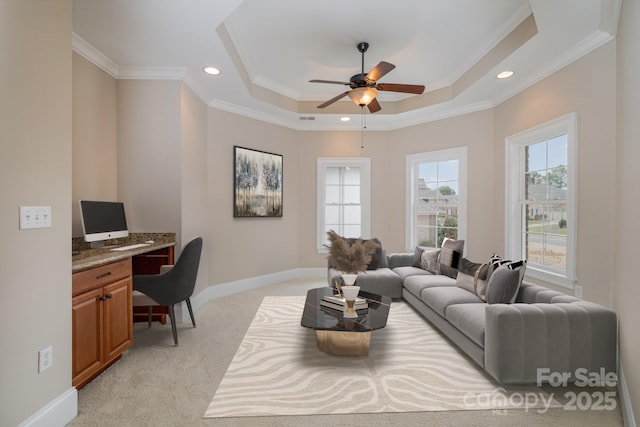 living room featuring light carpet, crown molding, a raised ceiling, and ceiling fan